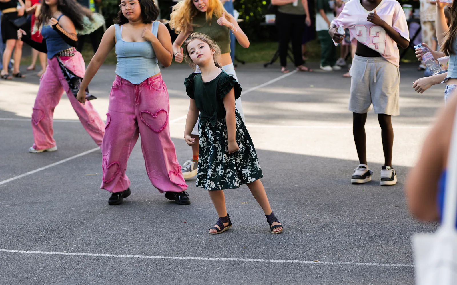 Une jeune participante danse au milieu d'un groupe réuni en plein air