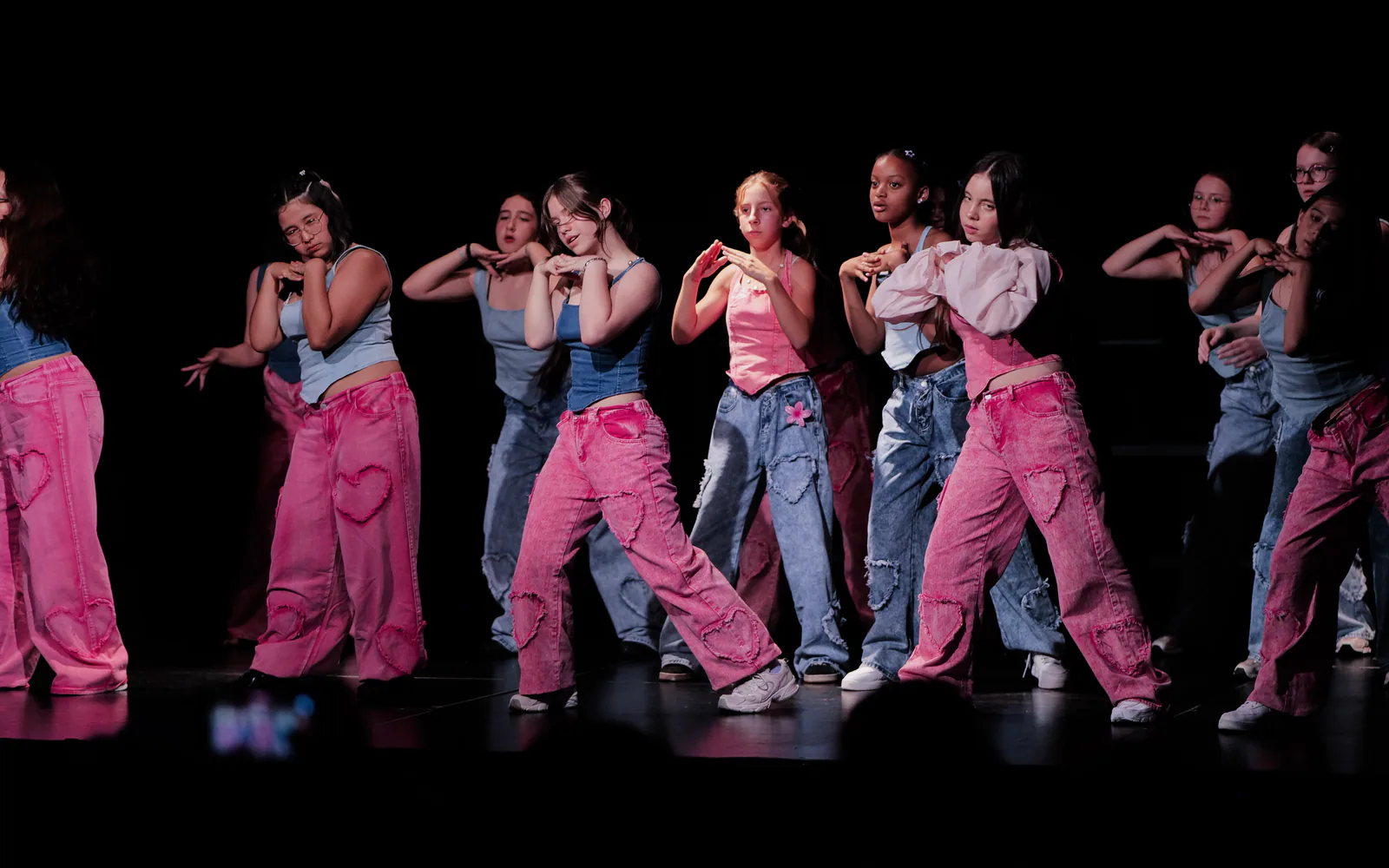 Groupe de jeunes danseuses pendant une chorégraphie K-pop sur scène