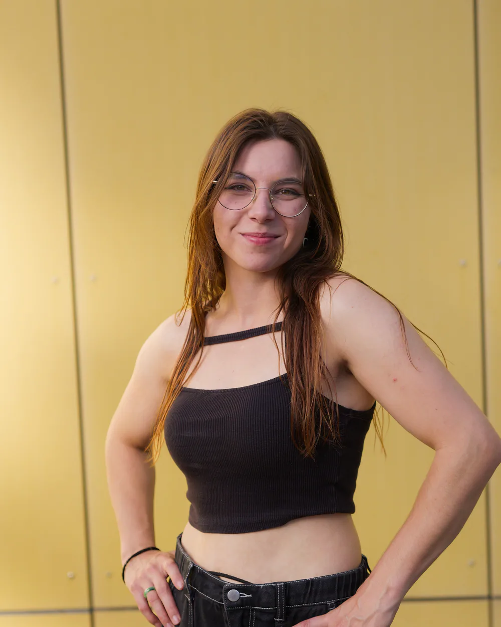 Portrait de Kassandra, enseignante de self-défense, devant une façade jaune