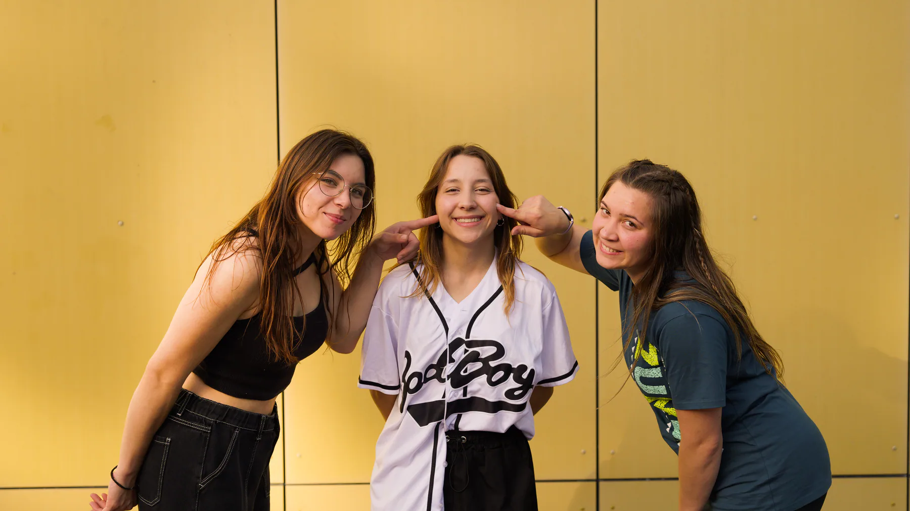 Trois membres d'ATIPIC réunies devant une façade jaune