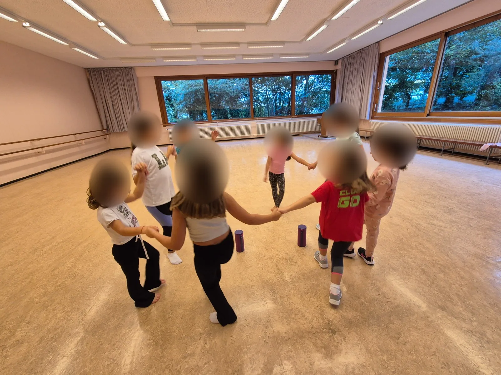 Des enfants forment une ronde pendant un cours, avec leurs visages anonymisés